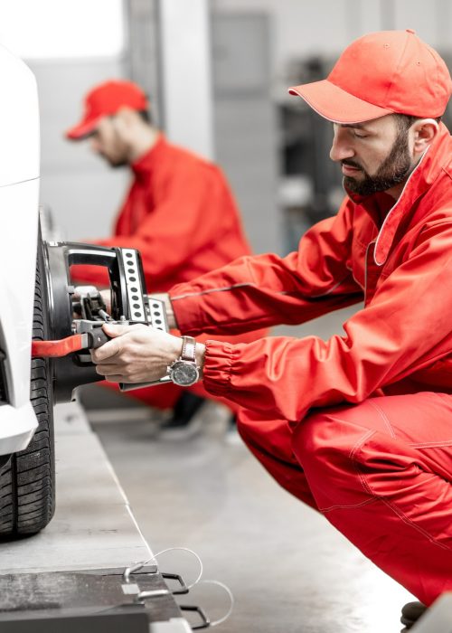 auto-mechanics-making-wheel-alignment-at-the-car-service.jpg
